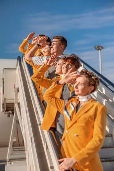 Mitarbeiter einer Fluggesellschaft stehen auf der Treppe eines Flugzeugs