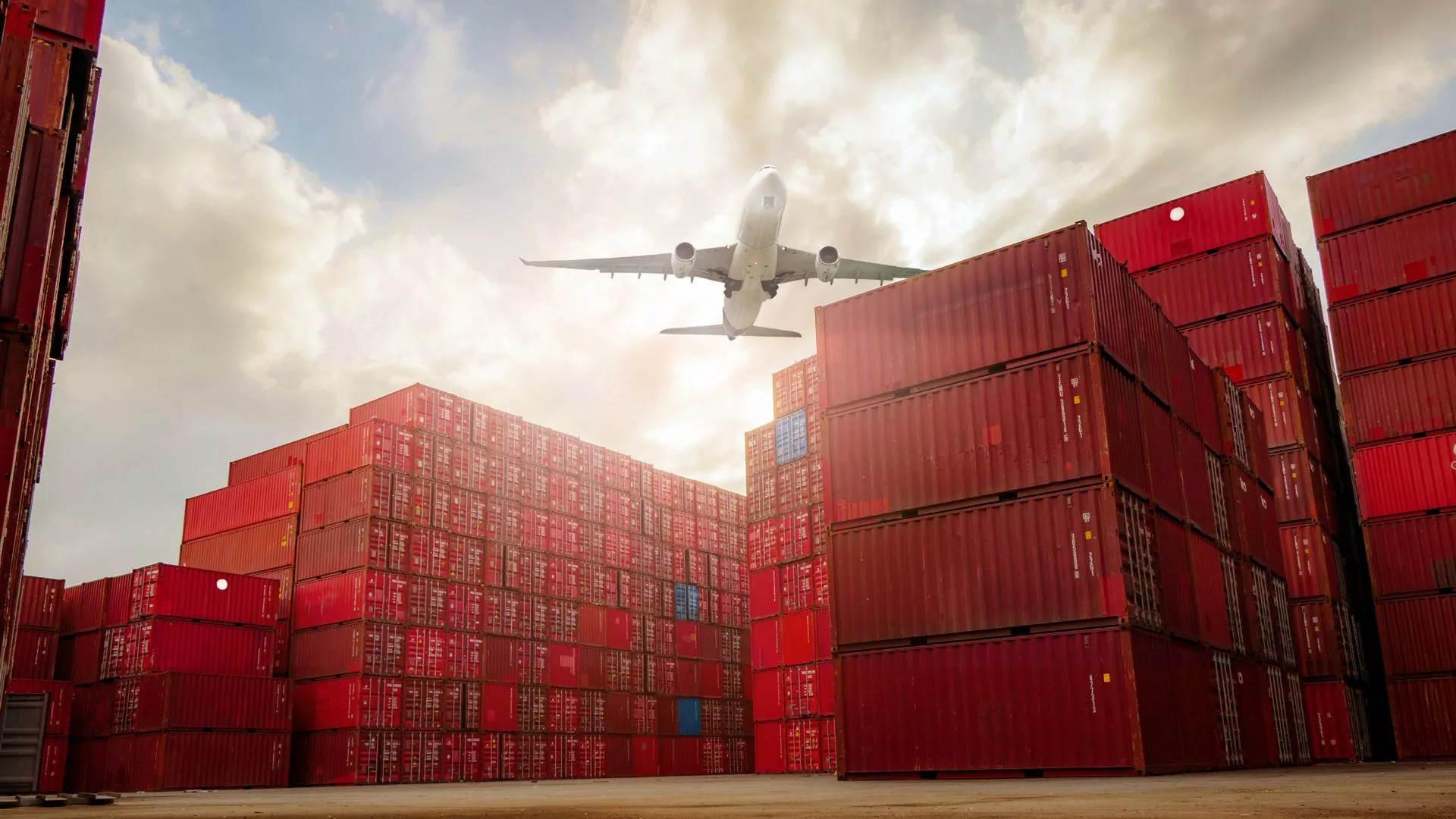 Flugzeug fliegt über Lager von Fracht-Containern