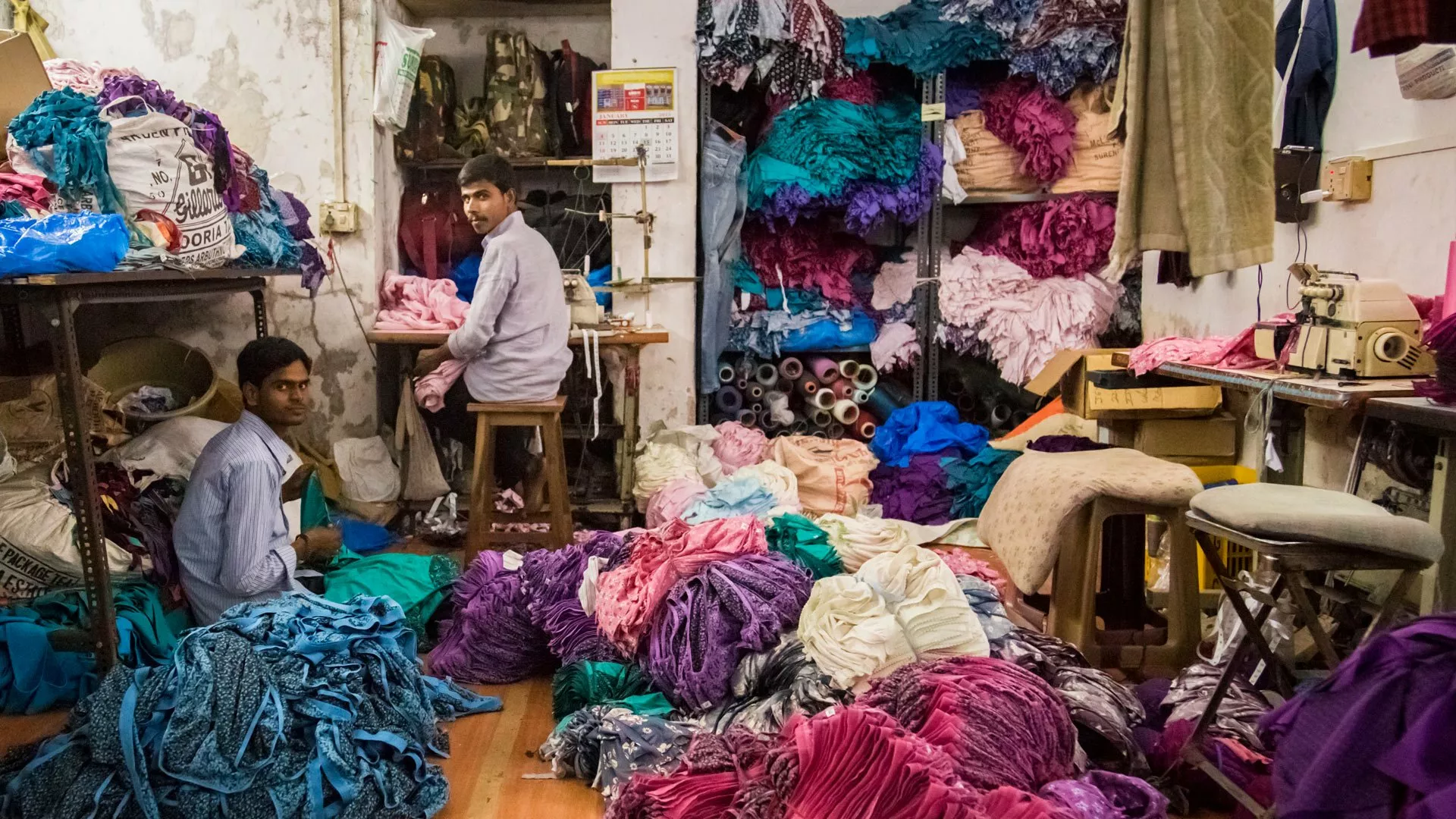 lieferkettengesetz_2_Arbeiter Zwei Männer arbeiten in einer kleinen Wäschefabrik im Slum von Dharavi.